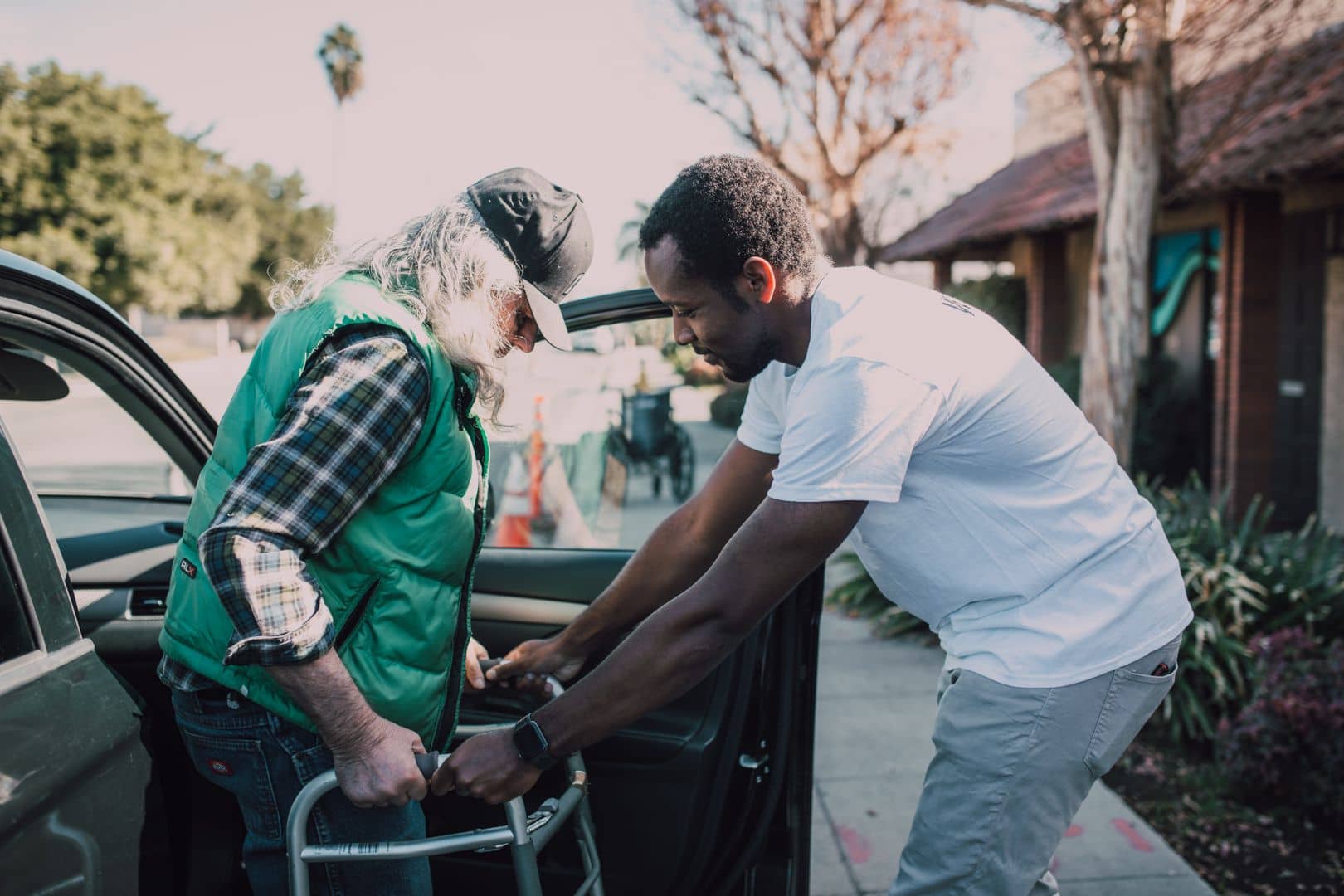 Driver helping a senior with a walker out of a vehicle — door-to-door medical transportation, Next Lane Transportation Houston
